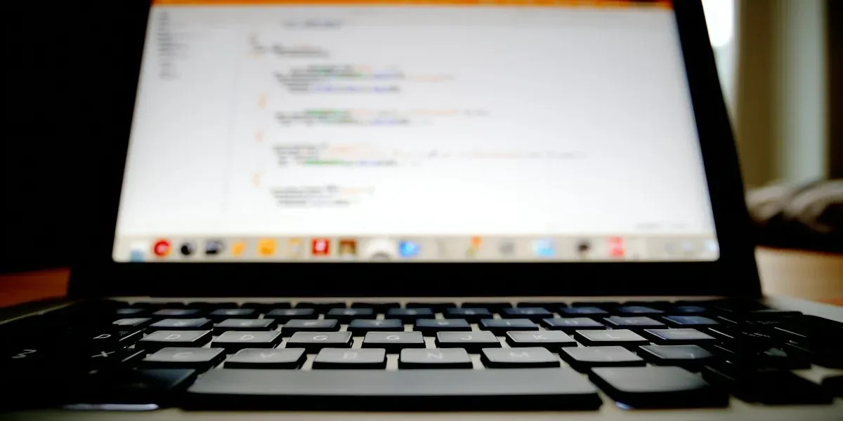 Close-up of a laptop screen showing code above the keyboard.